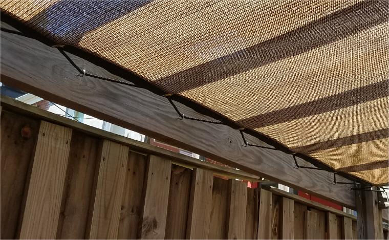 RopeLacing Tan&Black 80% knit shade panel laced to wood structure with 3/8 rope through perimeter grommets one foot centers