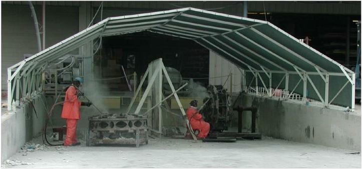 Green 60% knit shade fabric installed atop gambrel truss bolt-together shade structure provides outdoor work area