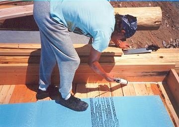 Caulking the perimeter for a tight seal before blueboard foam insulation is applied. No need for vapor barrier.