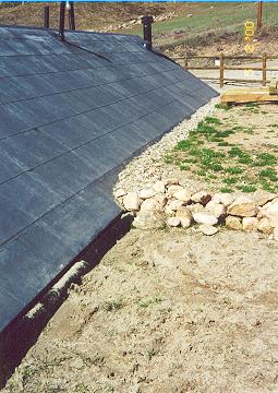 North wall is at grade, bermed into the hillside with drainage pipe at left still showing before it was backfilled